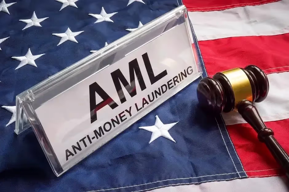 Sign reading AML Anti-Money Laundering on a US flag beside a judge's gavel
