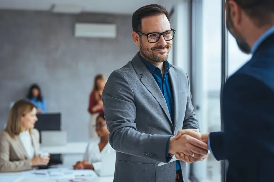 Smiling businessman shaking hands with a colleague in an office meeting