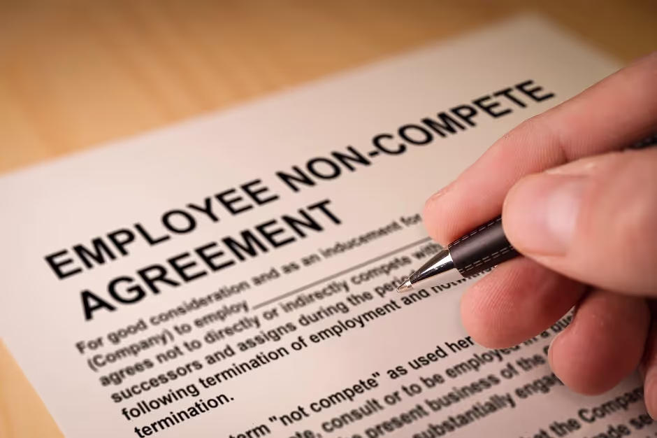Hand signing an employee non-compete agreement with a pen