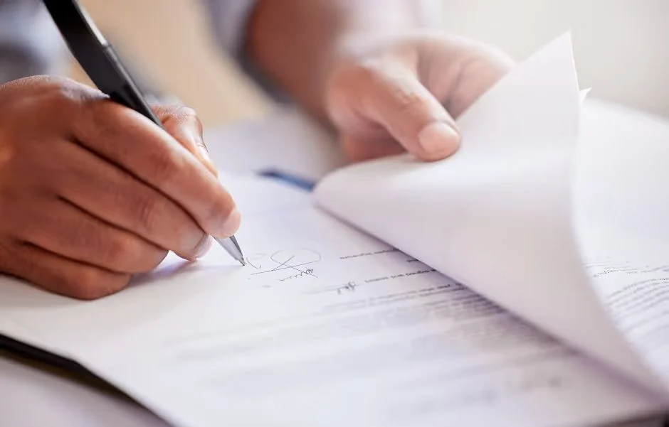 Hand signing a multi-page document with a pen