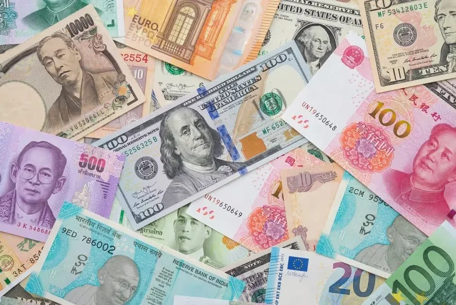 Banknotes from many countries spread out, including dollars, yuan, yen and euros