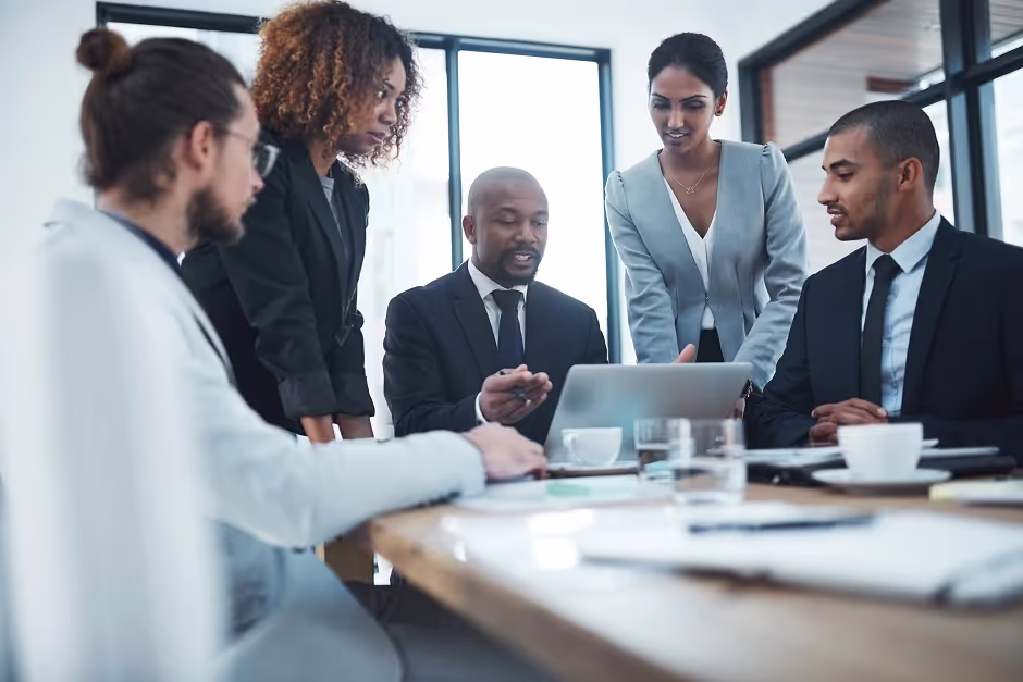 Diverse business team discussing work around a laptop in a meeting