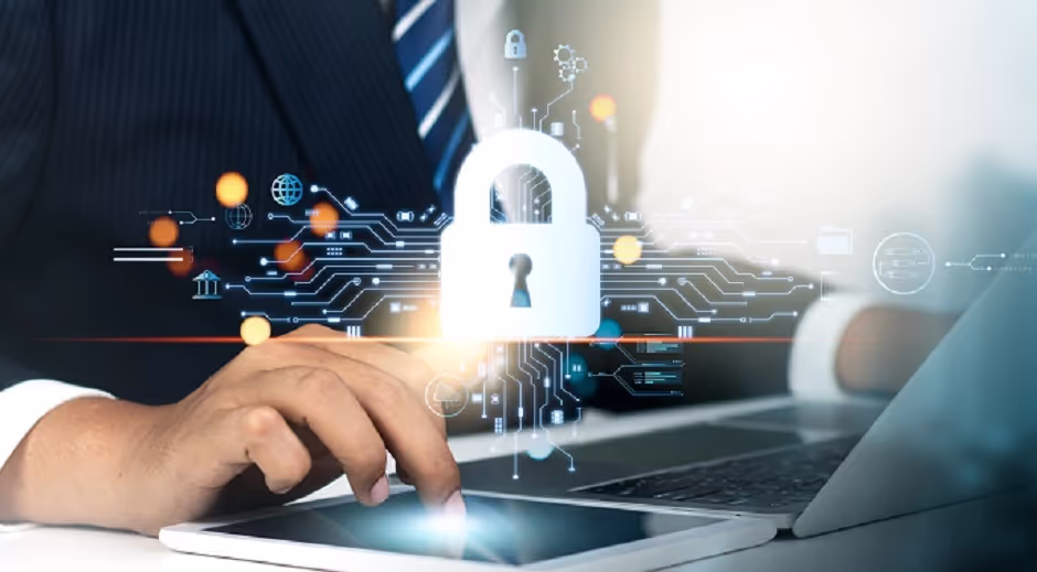 Person at a laptop under a glowing digital padlock and circuit graphic