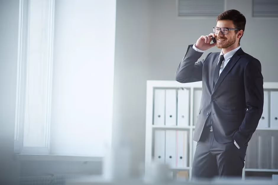 Businessman in a suit talking on his phone in an office