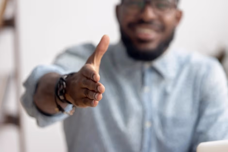 Smiling man extending his hand for a handshake