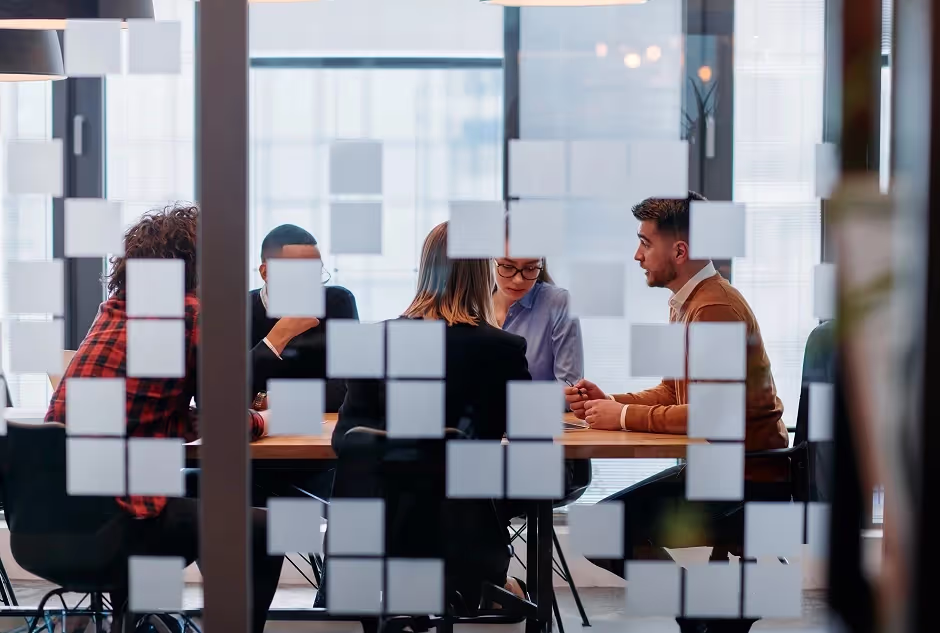 Business team meeting seen through a frosted glass office wall