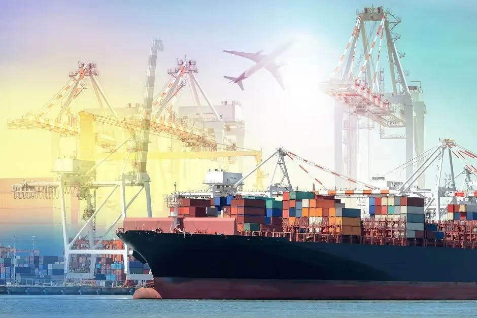 Cargo ship loaded with shipping containers at a port with cranes and a passing plane