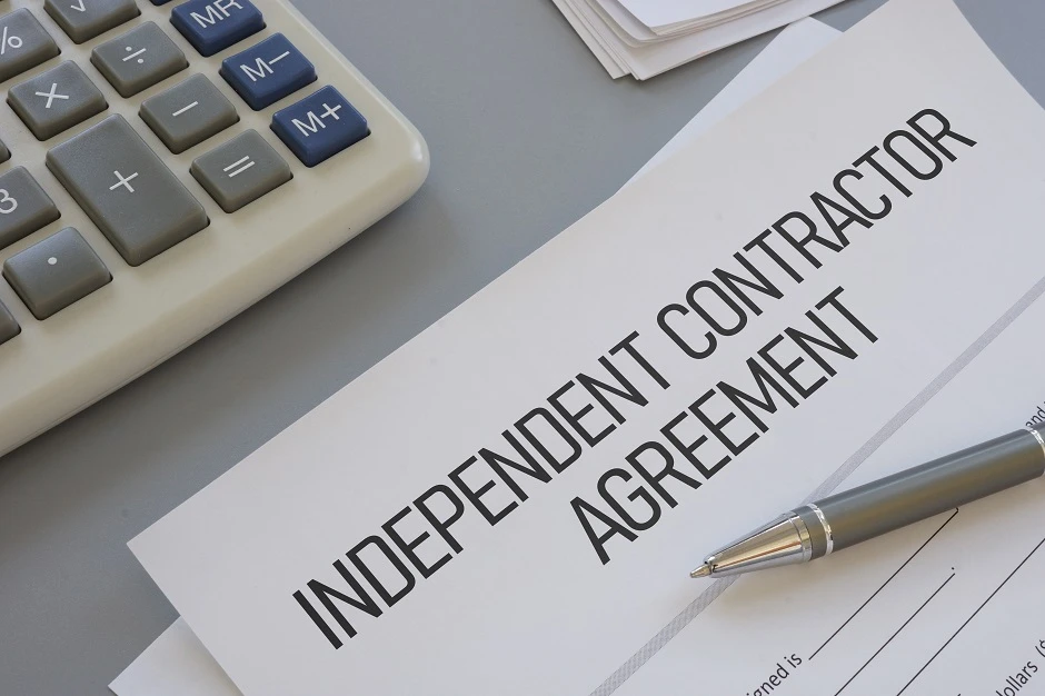 Independent Contractor Agreement document with a pen beside a calculator