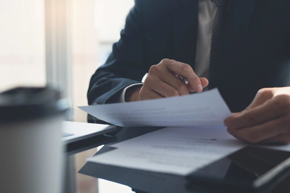 Businessman in a suit reading paperwork at a desk